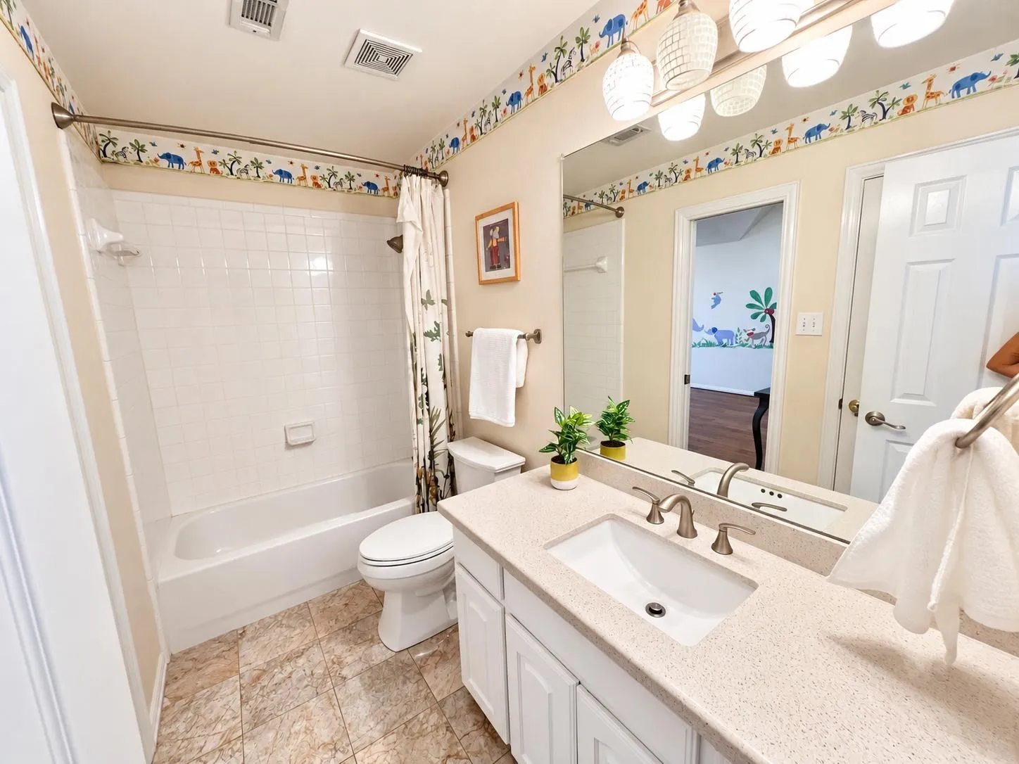 Bathroom featuring a single vanity with an integrated sink, brushed nickel faucet, large wall mirror, and overhead lighting
