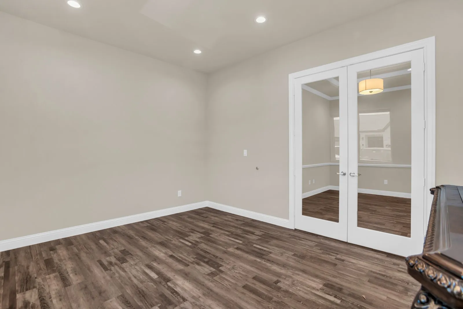 Recessed lighting, wood-finish flooring, and double glass-paneled doors