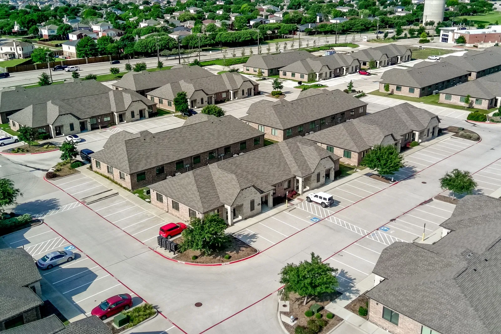 Multiple buildings with brick and stone exteriors, gabled roofs, and dedicated parking areas