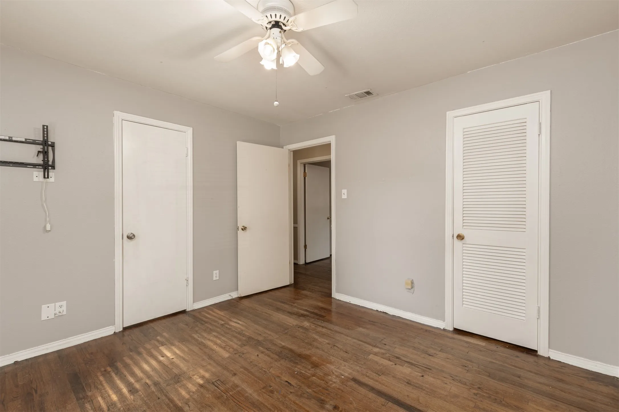 Hardwood flooring, painted walls, white trim, and a ceiling fan with integrated lighting