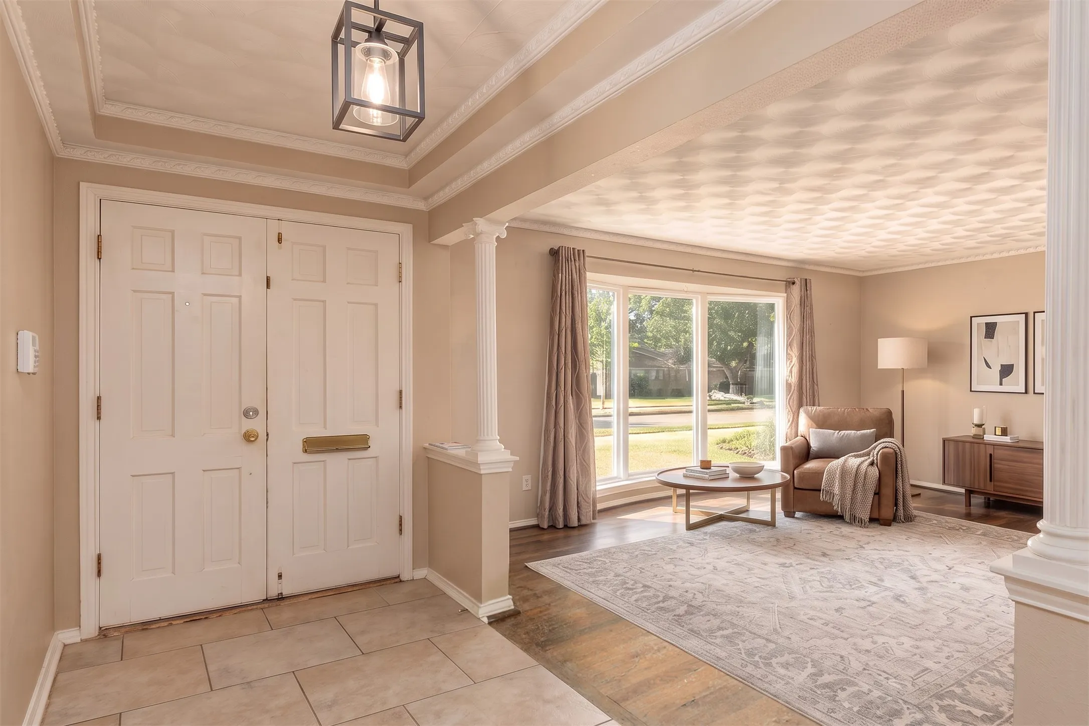 Entryway featuring double panel doors, decorative ceiling with recessed squares, tiled flooring, and a columned archway