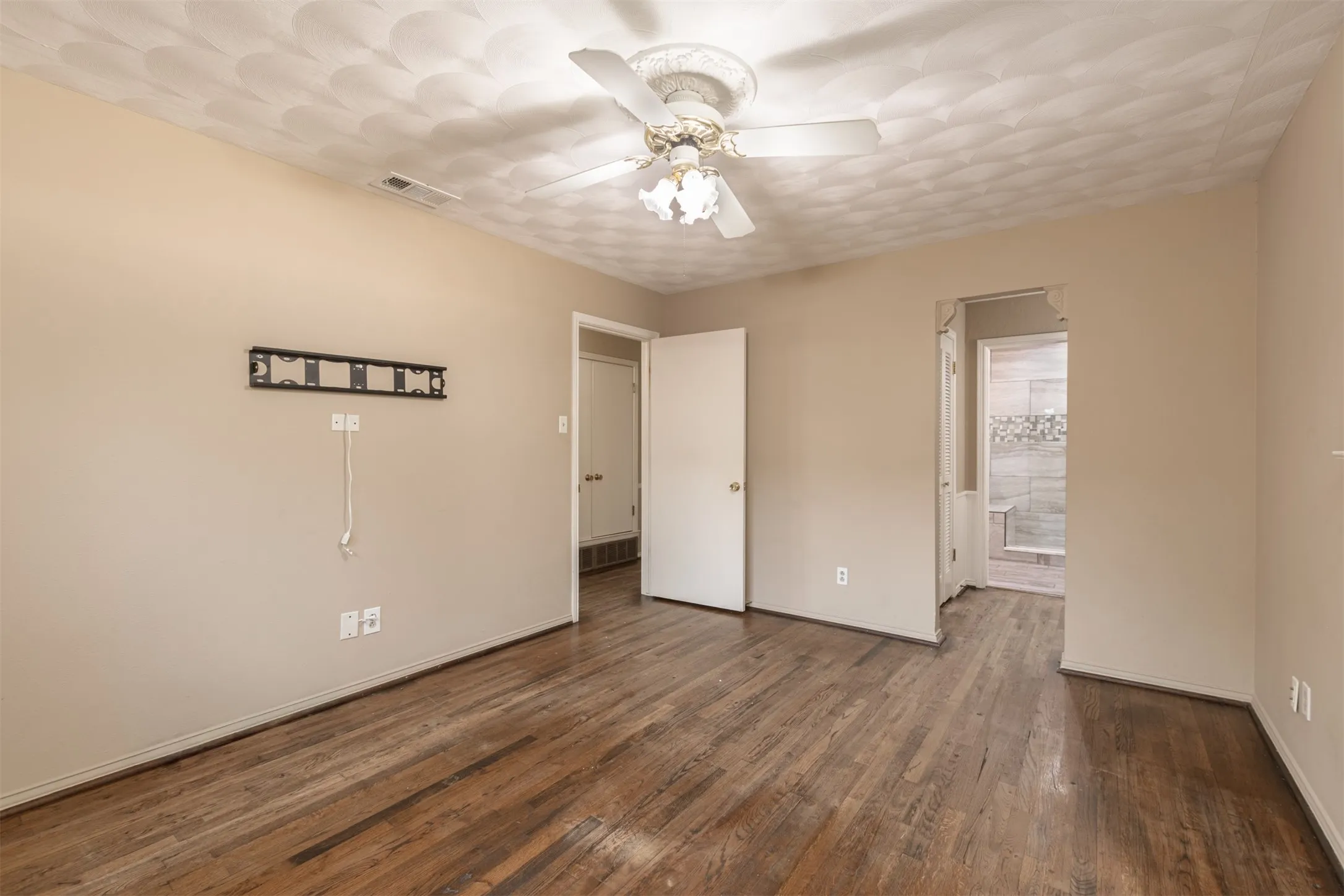 Hardwood flooring, neutral wall tones, and a ceiling fan with integrated lighting