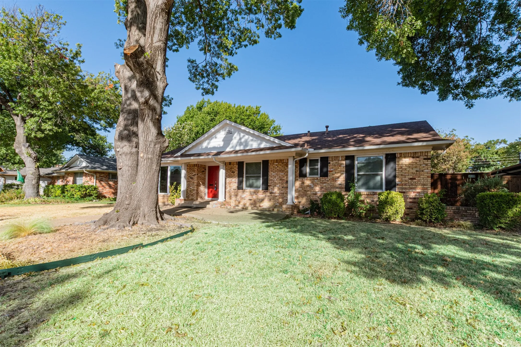 Brick exterior featuring a gabled roofline and an inviting red front door
