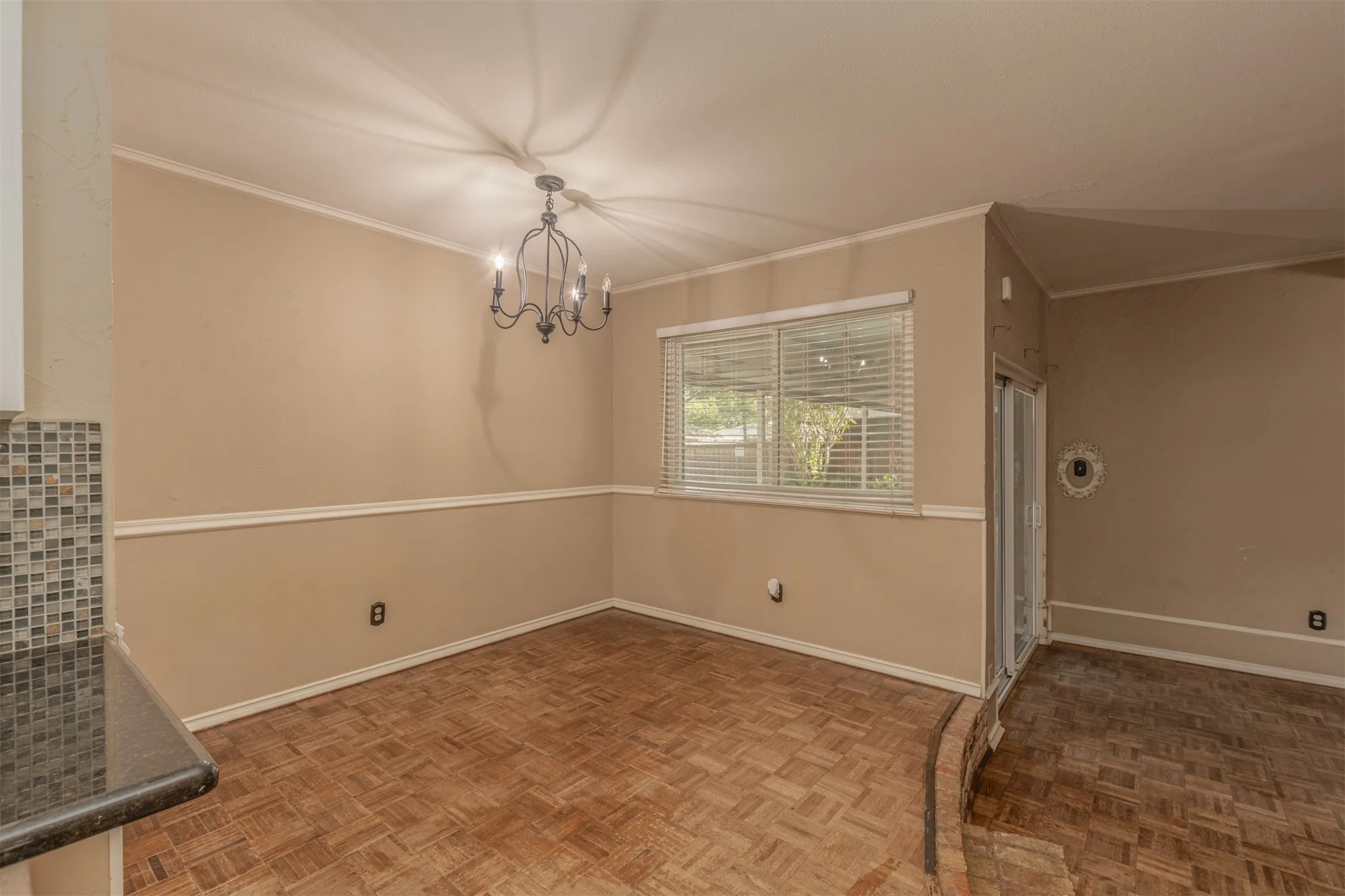 Recessed lighting, crown molding, chair rail molding, wood-finish flooring, and a chandelier