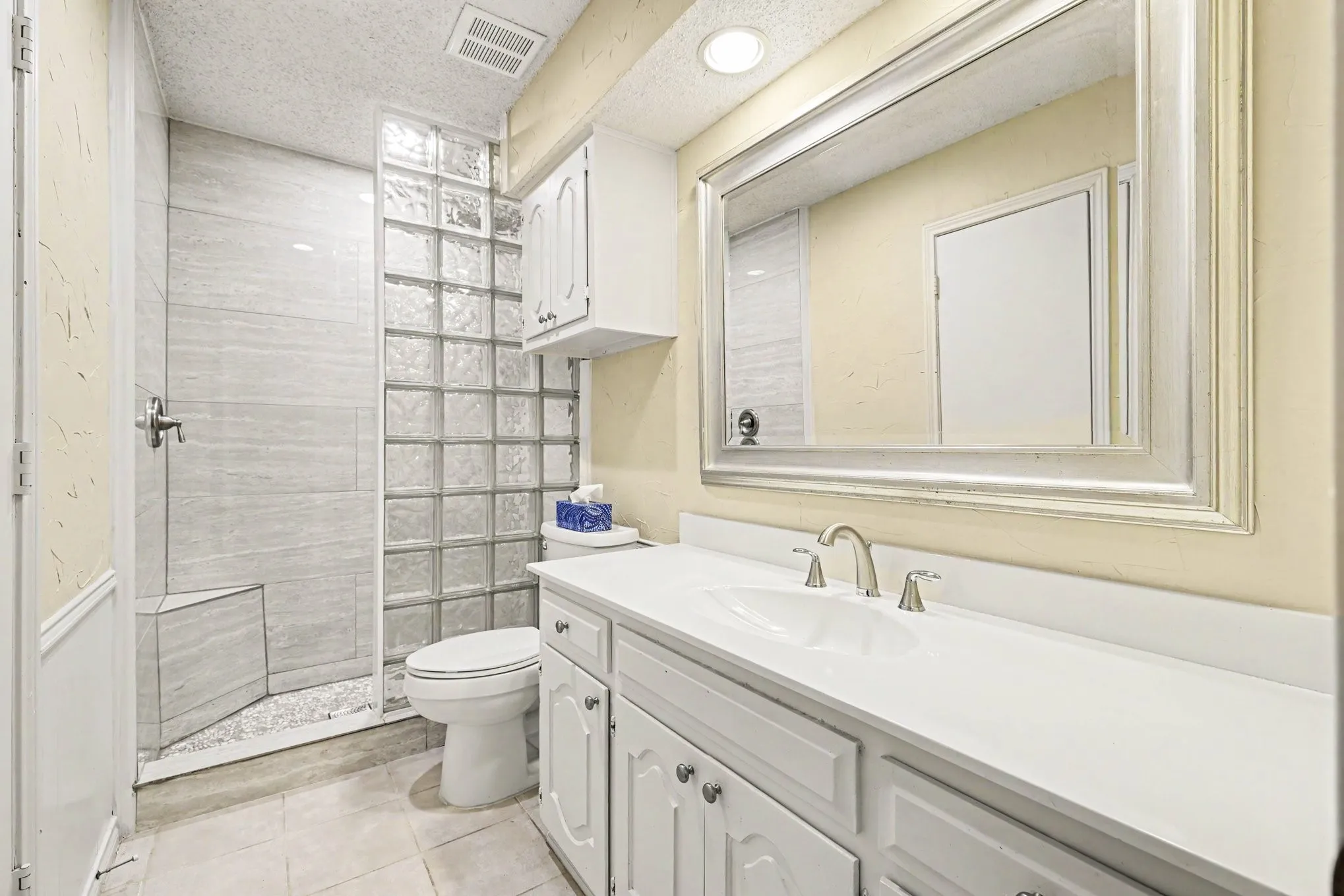 Walk-in shower with tiled walls and a built-in bench