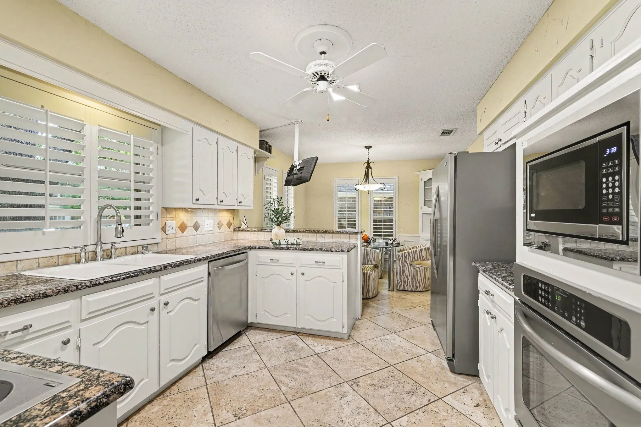 Kitchen featuring white cabinetry, stone-finish countertops, stainless steel appliances, and tile flooring