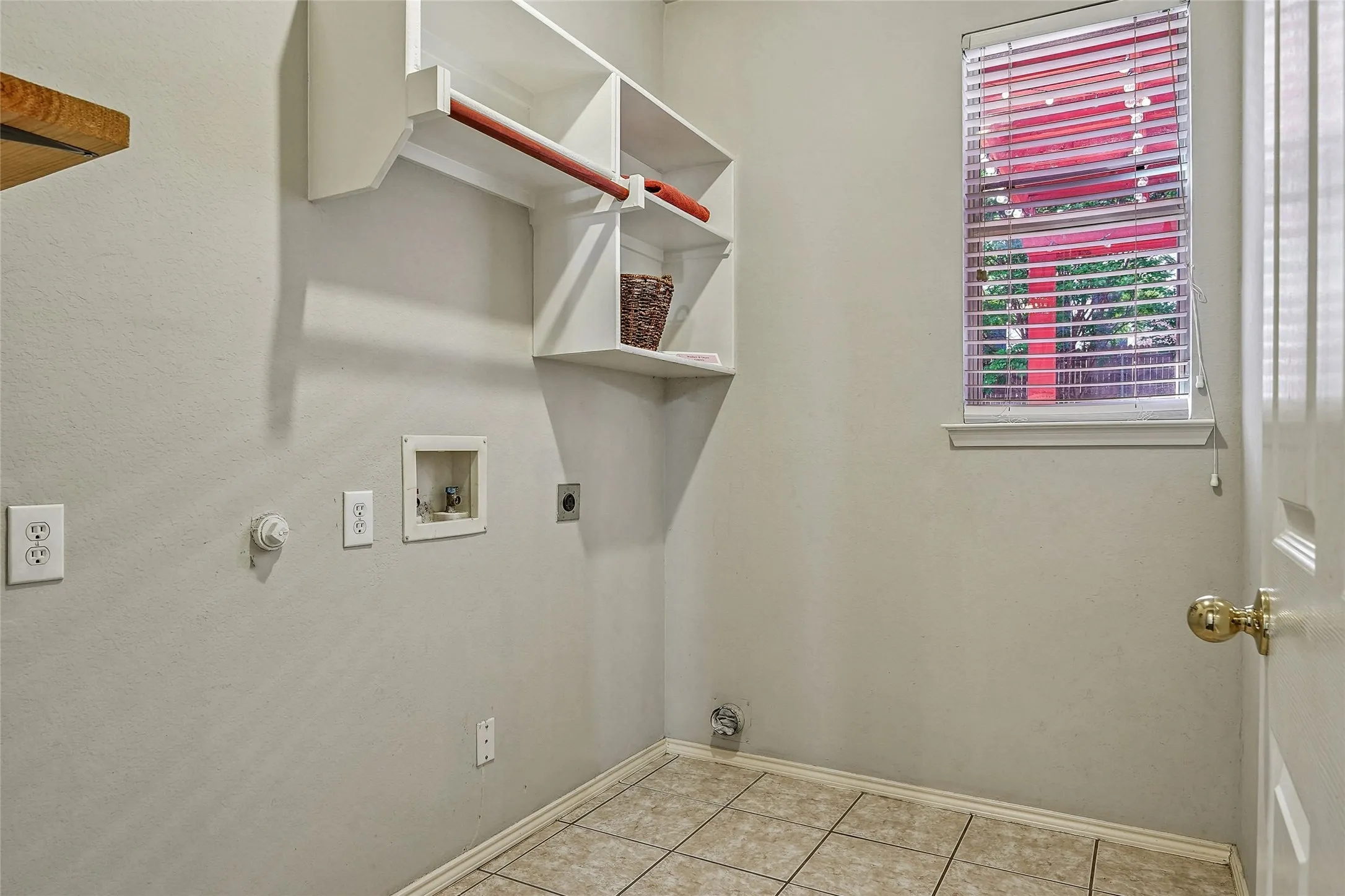 Laundry area featuring hookup for a washing machine, electric dryer hookup, hookup for a gas dryer, light tile patterned floors, and a textured wall