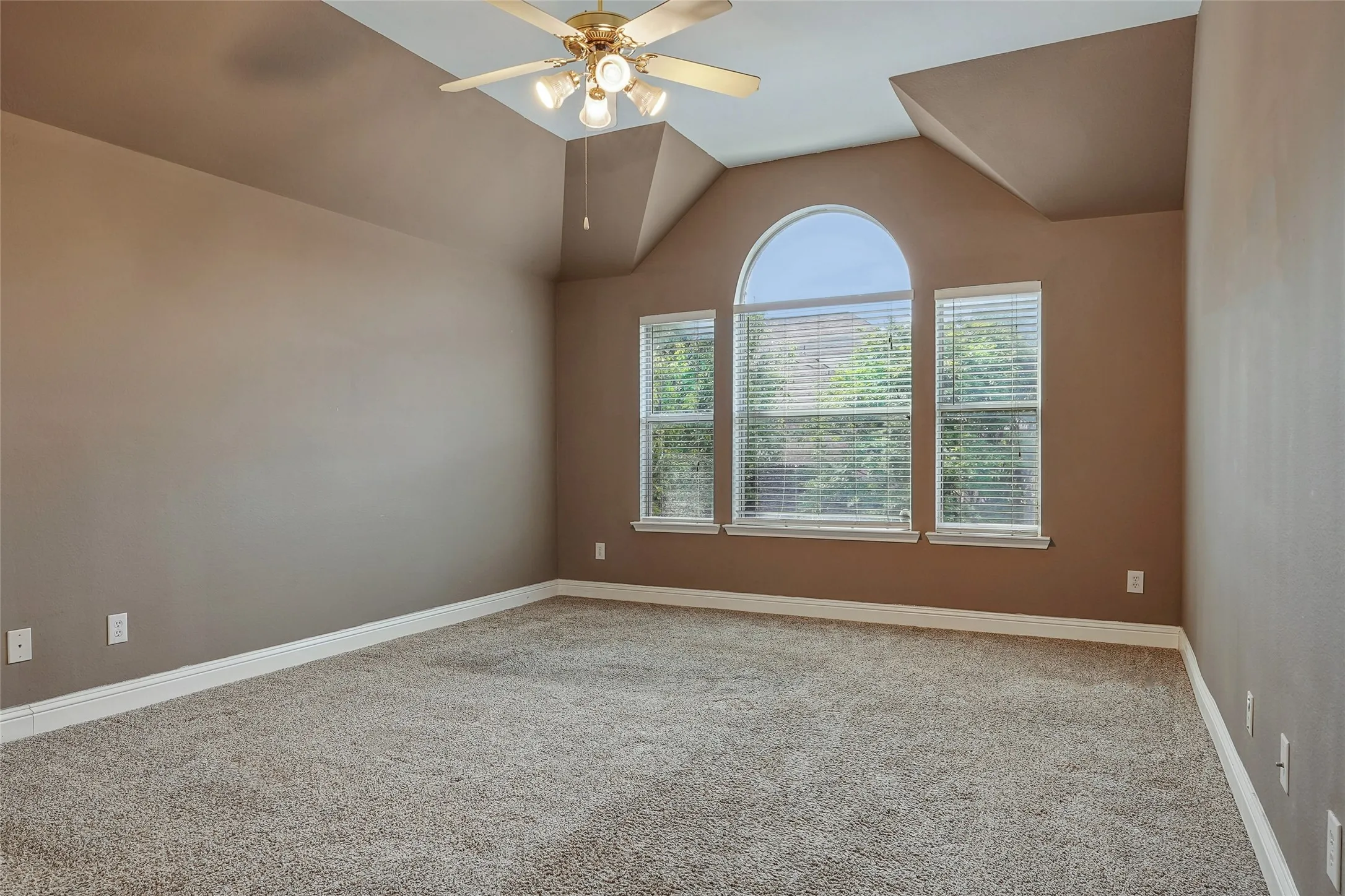 Unfurnished room with light colored carpet, a ceiling fan, and vaulted ceiling