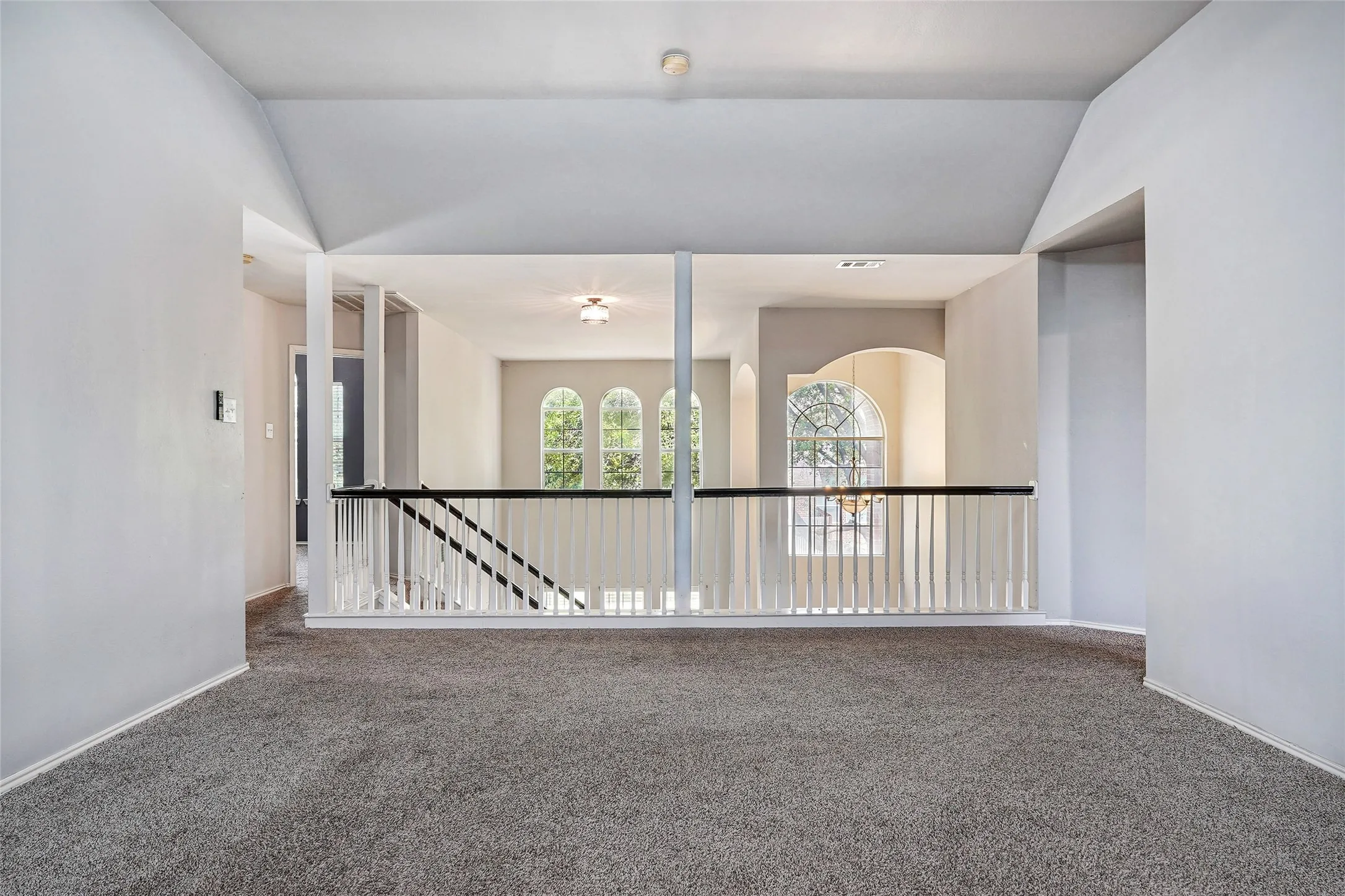 Empty room with carpet flooring and lofted ceiling