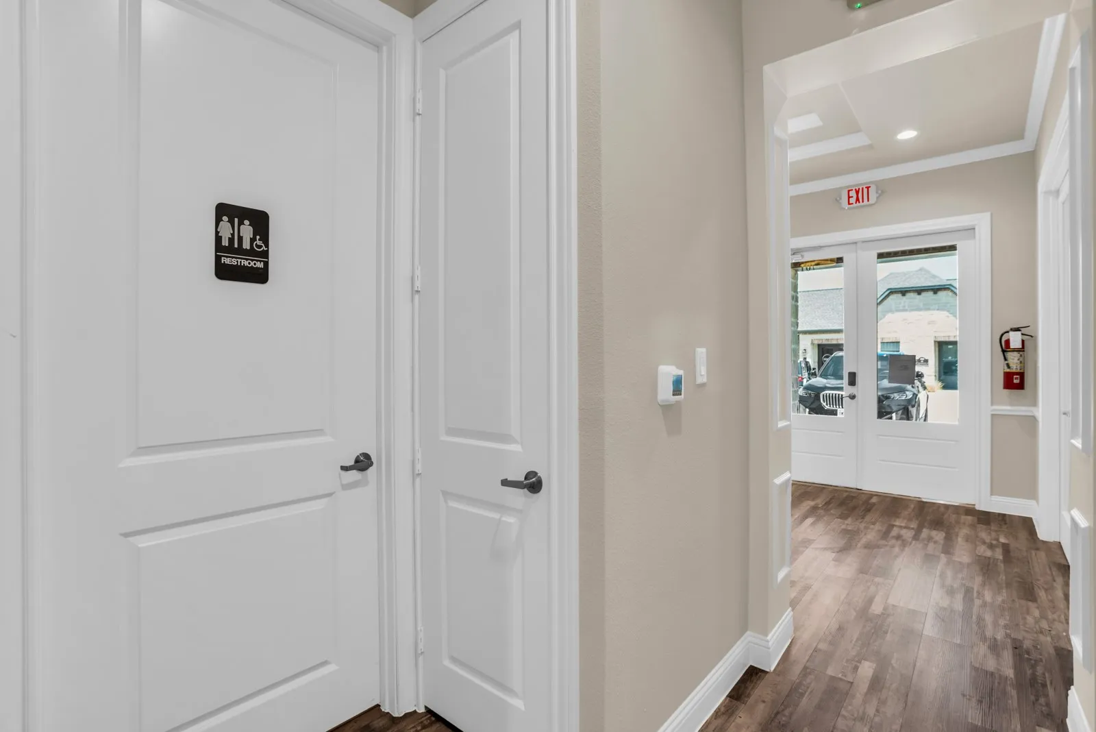 Wide plank wood-finish flooring extends through the hallway