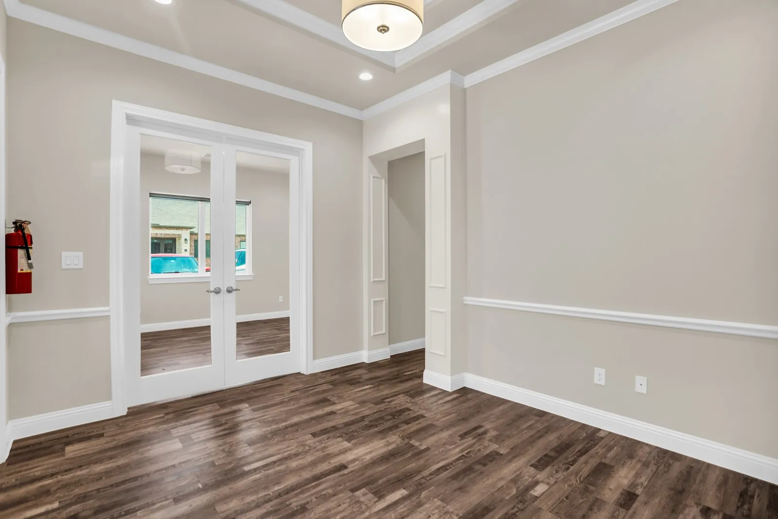 Recessed lighting, wood-finish flooring, French doors with glass panels, crown molding, and wainscoting