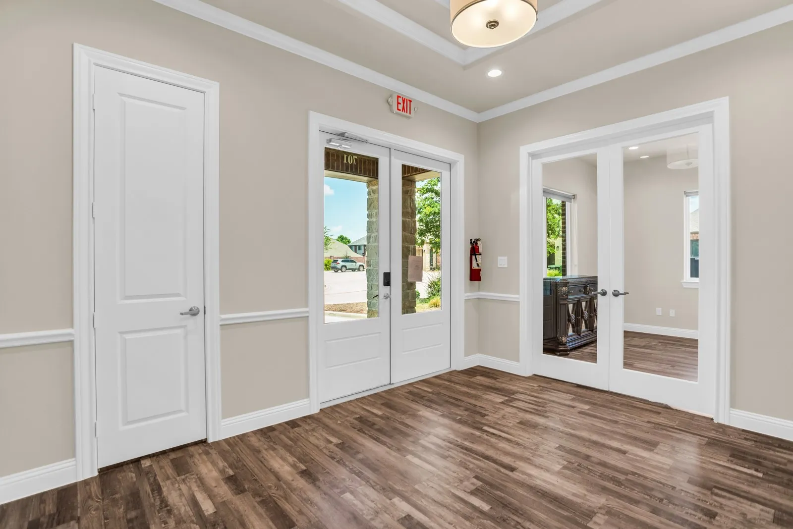 Wood-finish flooring, white trim and wainscoting, recessed lighting, and a semi-flush mount ceiling fixture