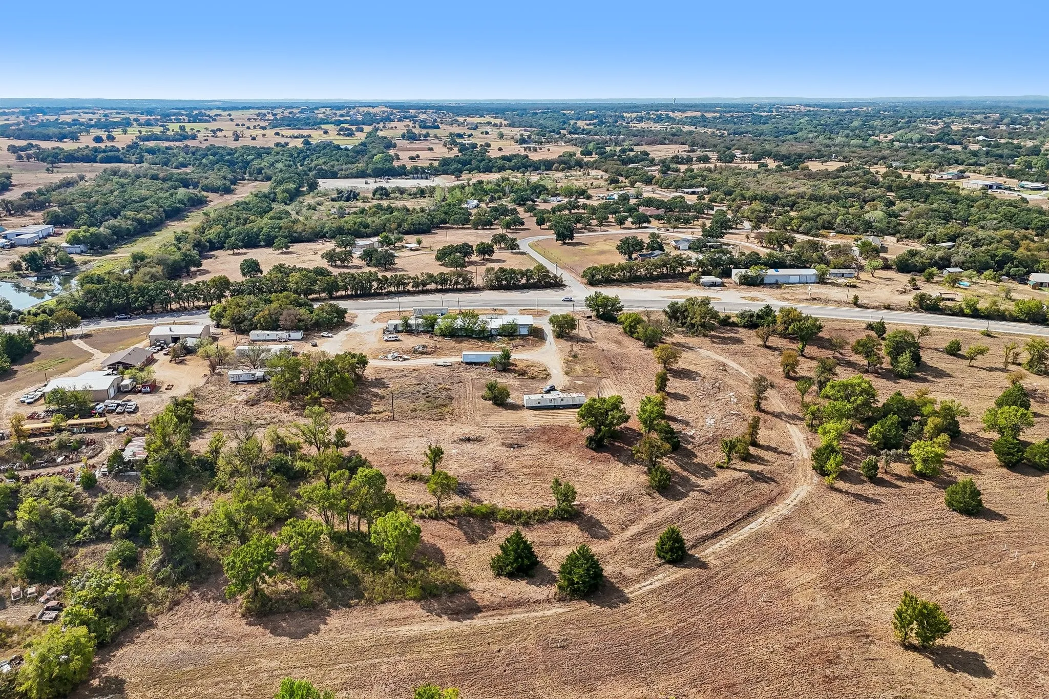 Expansive rural landscape featuring scattered trees and open land