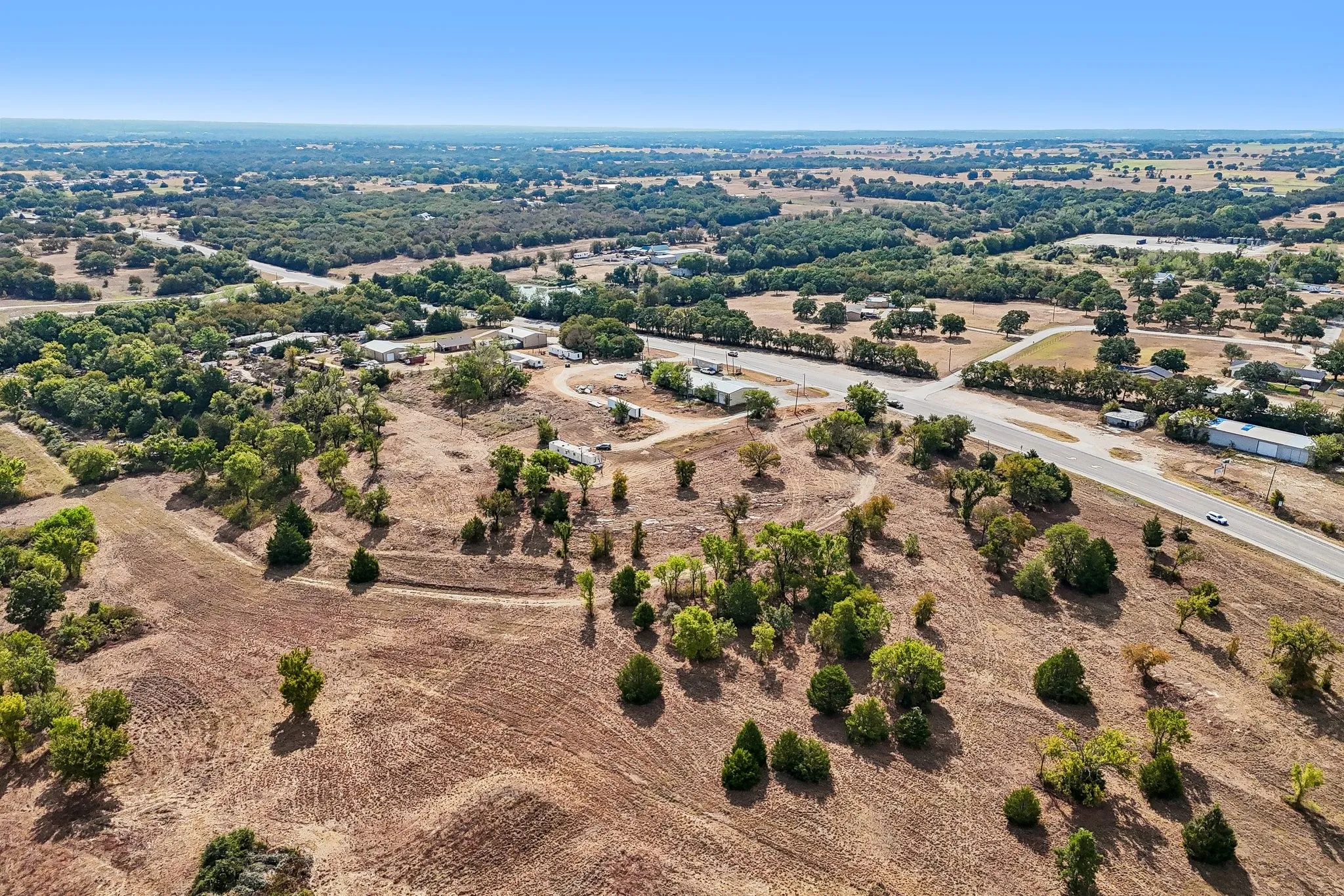 Expansive land featuring natural terrain and mature trees
