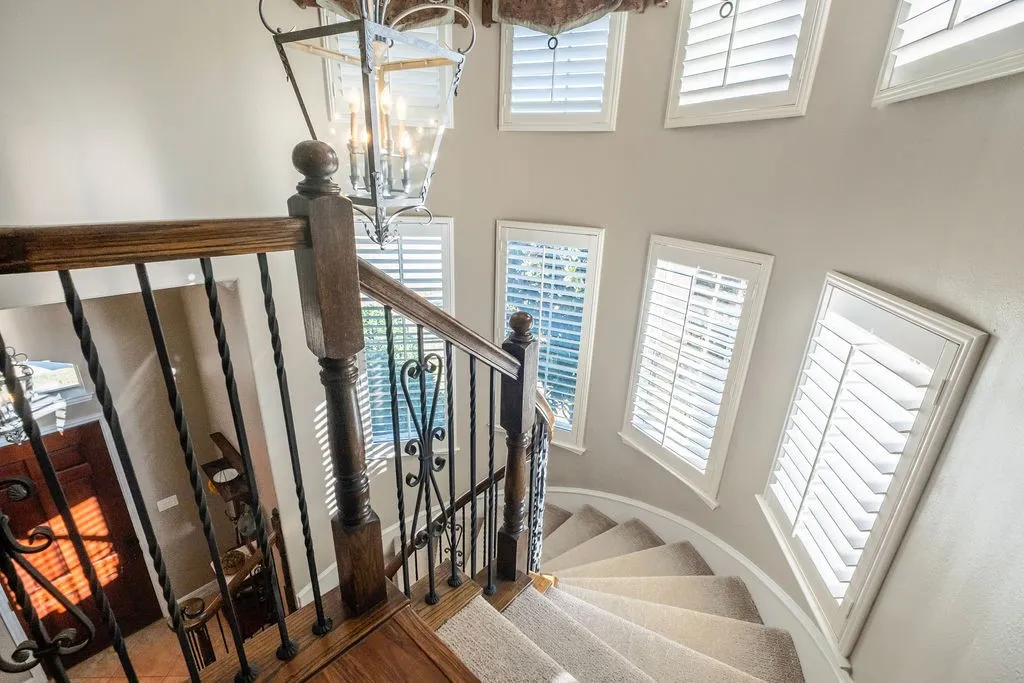 Curved staircase, wrought iron, plantation shutters