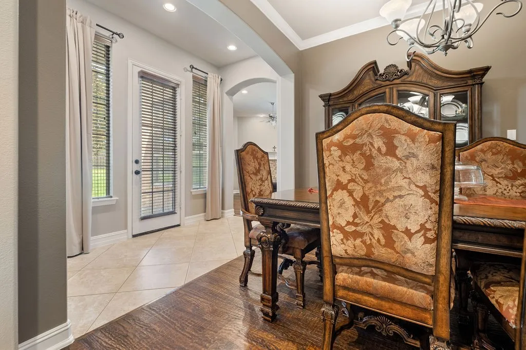 Recessed lighting, crown molding, wood-finish flooring, tiled flooring, and an arched doorway