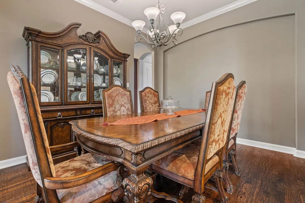 Hardwood flooring, crown molding, and an arched doorway