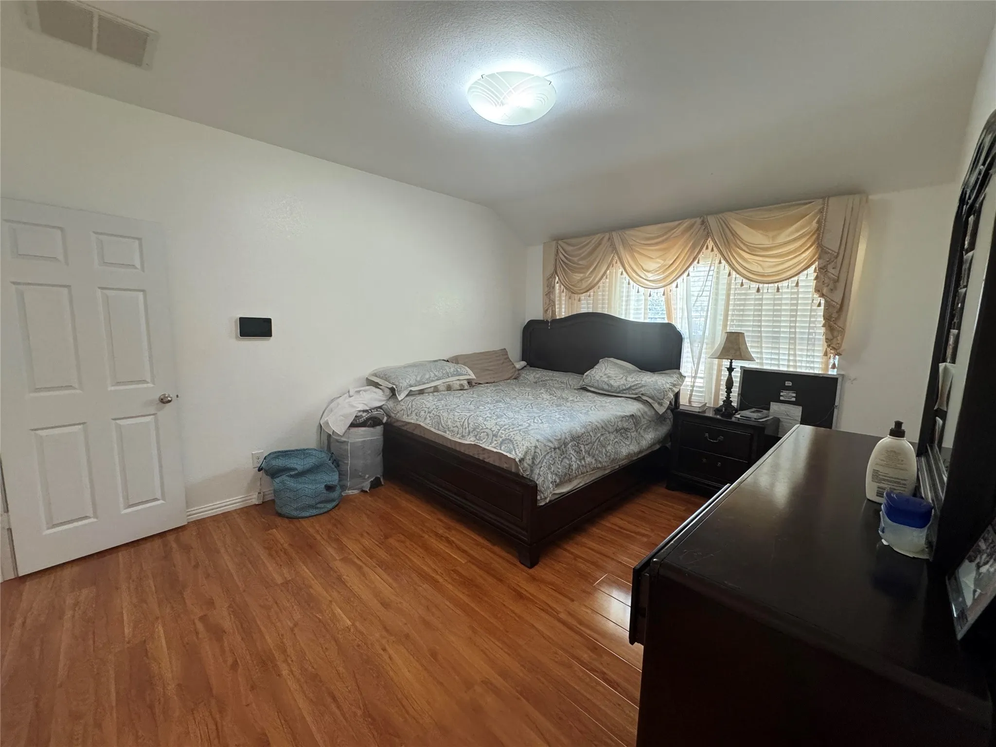 Wood-finish flooring with a flush-mounted ceiling light fixture
