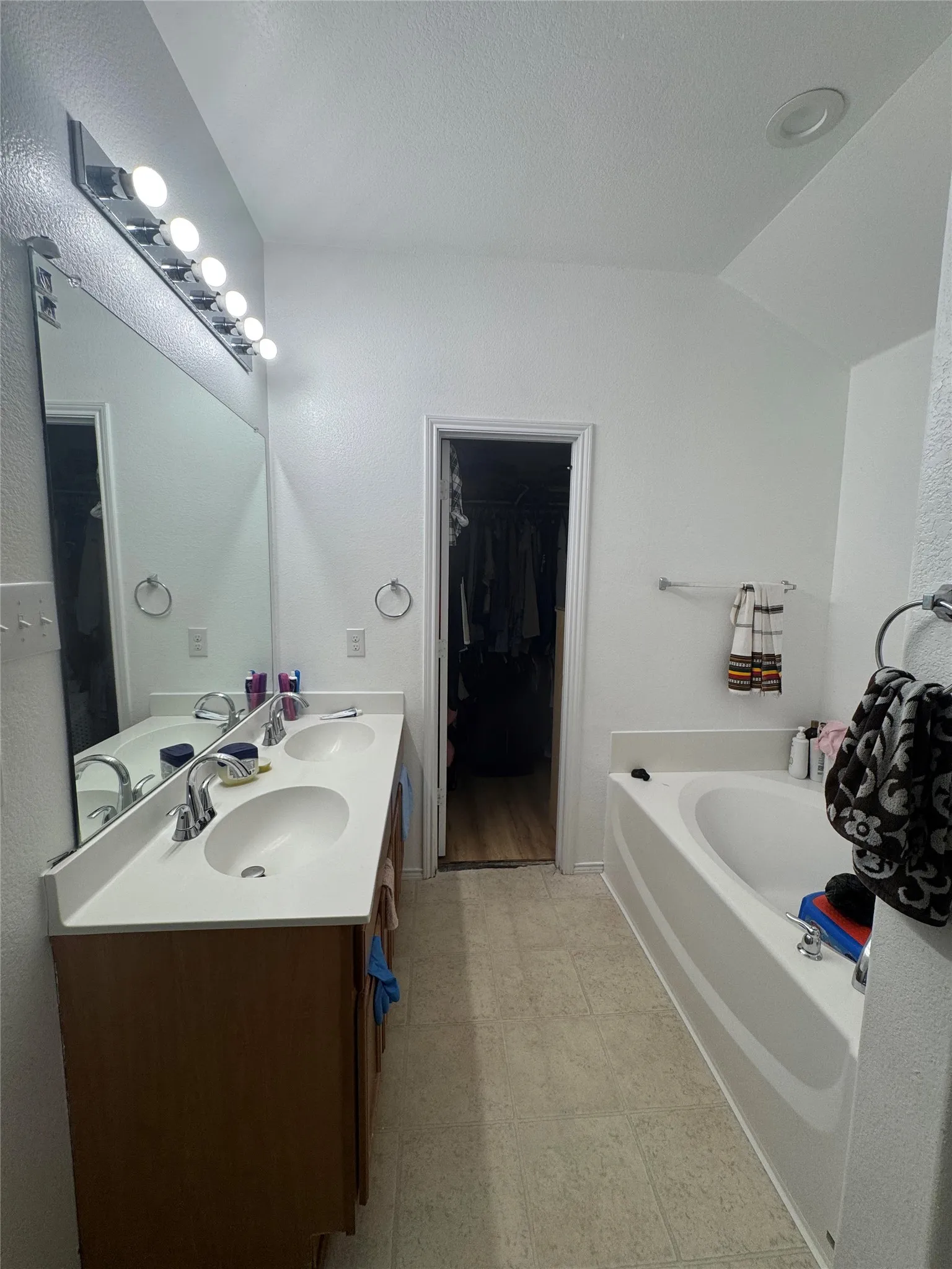 Double vanity with integrated sinks, chrome fixtures, and wood-finish cabinetry
