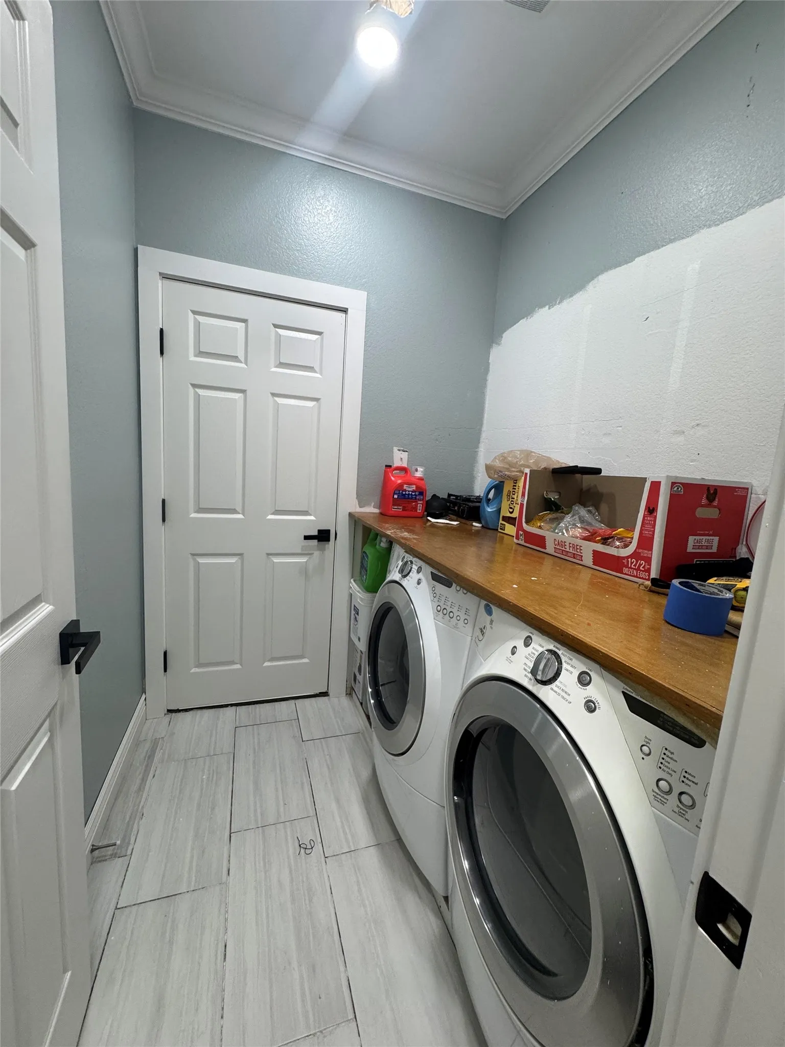 Crown molding, recessed lighting, wood-finish countertop, and tile flooring
