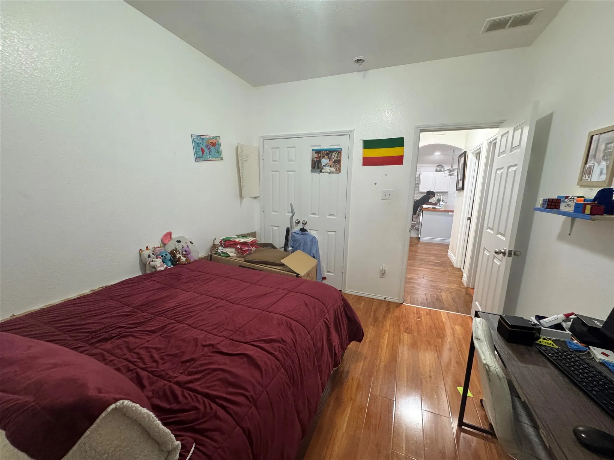 Wood-finish flooring with white walls and a vaulted ceiling