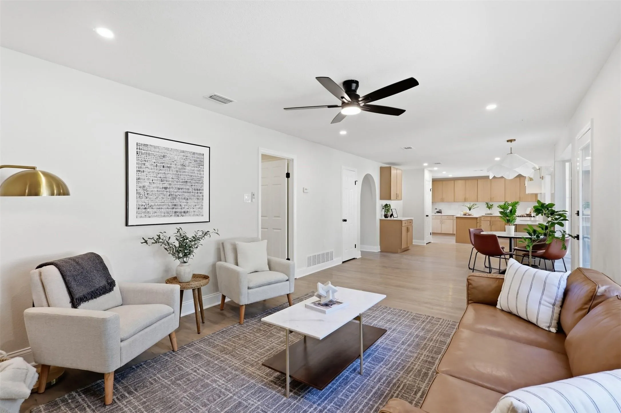 Recessed lighting, wood-finish flooring, ceiling fan, arched doorway, and built-in cabinetry