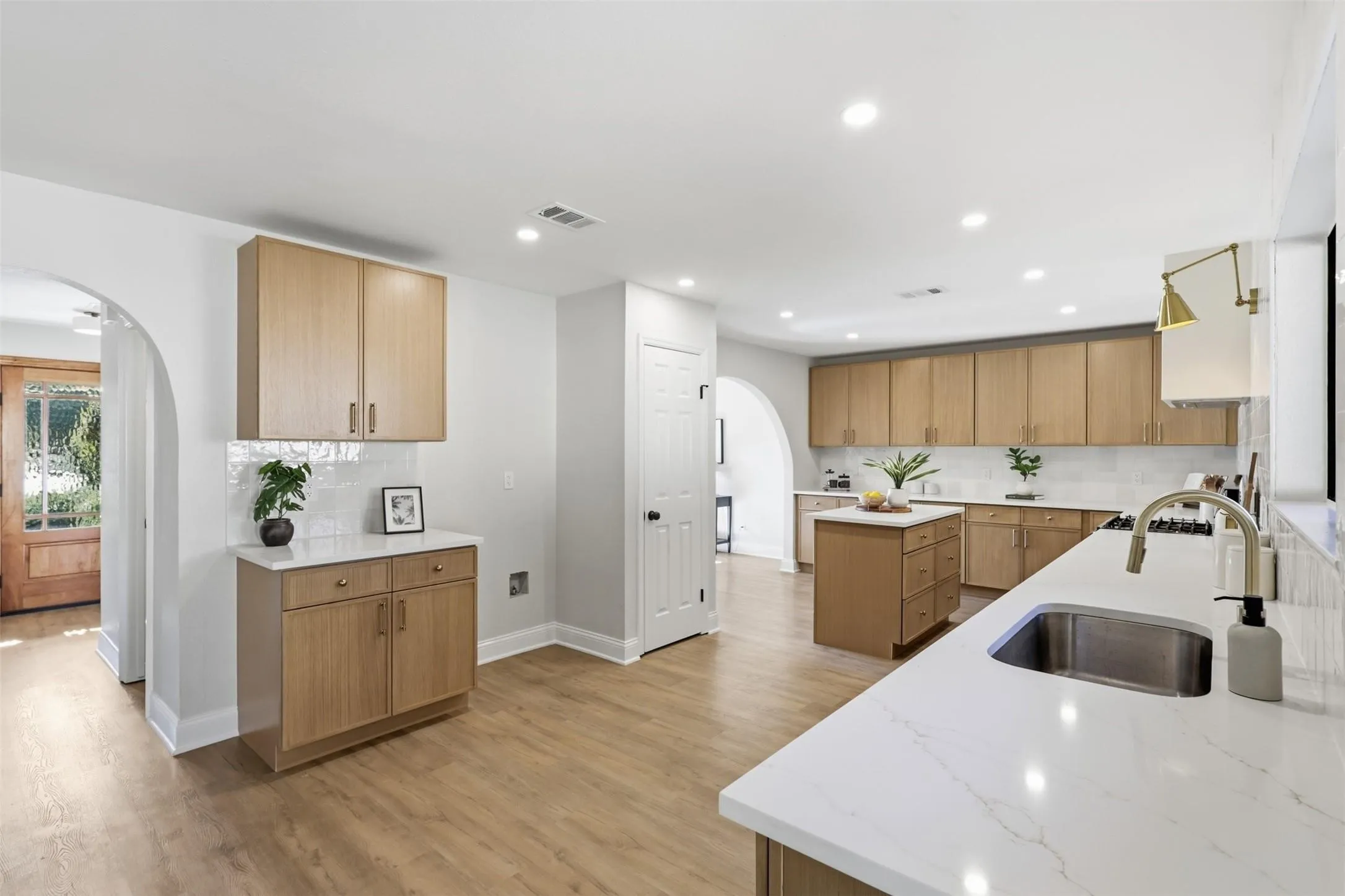 Spacious kitchen with wood-finish cabinetry, white countertops, a tile backsplash, and recessed lighting