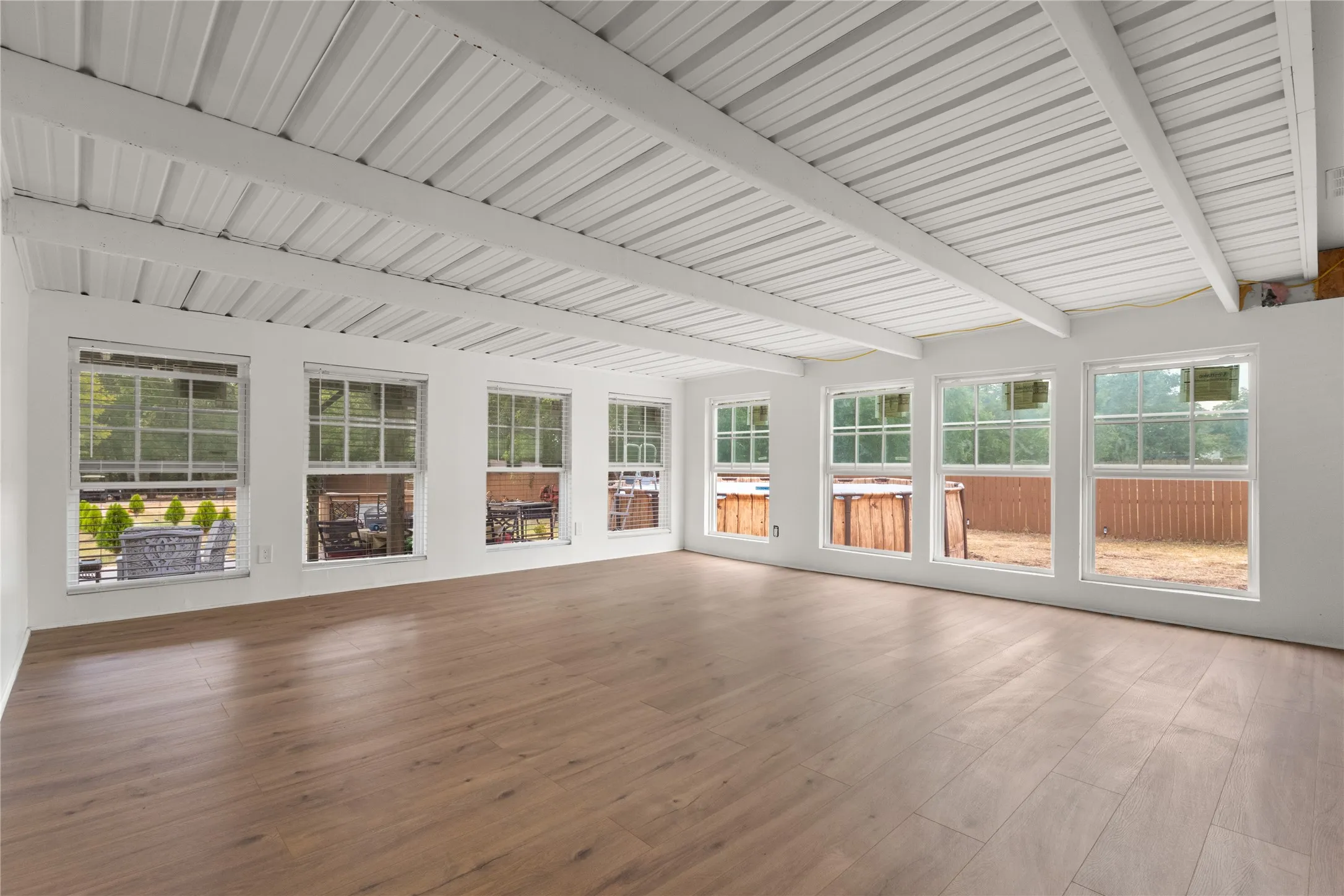 Wood-finish flooring with a white exposed beam ceiling