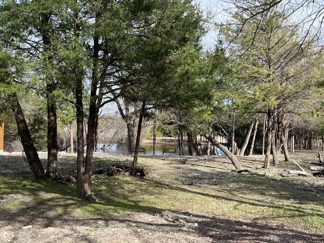 Wooded property featuring mature trees and a tranquil water feature