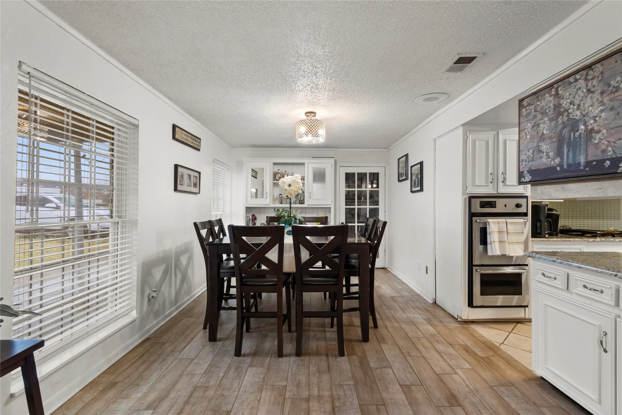 Wood-finish flooring throughout, with white cabinetry and stainless steel double ovens