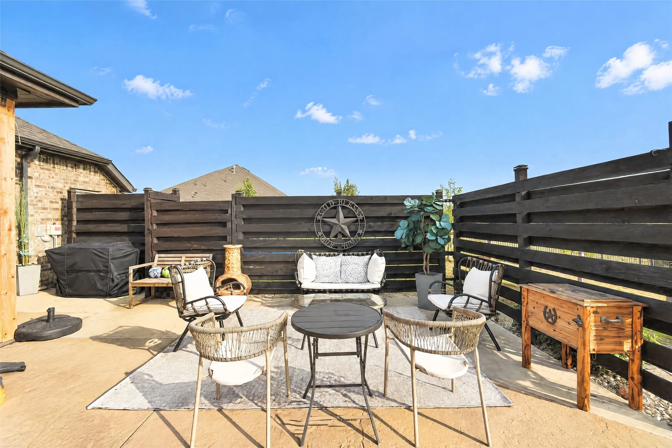 Outdoor patio featuring a stamped concrete surface and dark wood privacy fencing