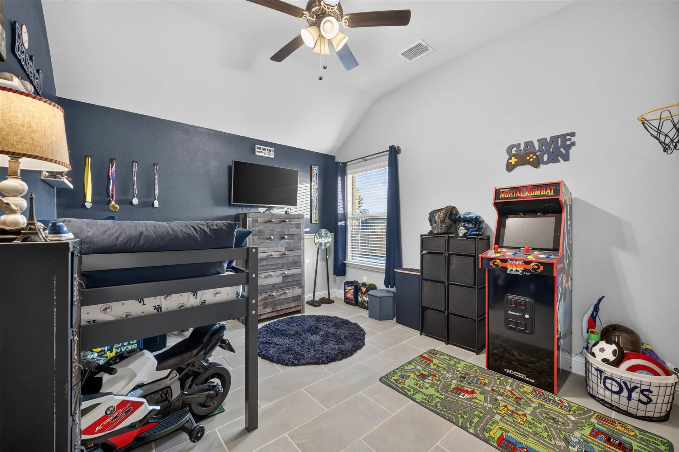Vaulted ceiling with a ceiling fan, recessed window, and light-toned tile flooring