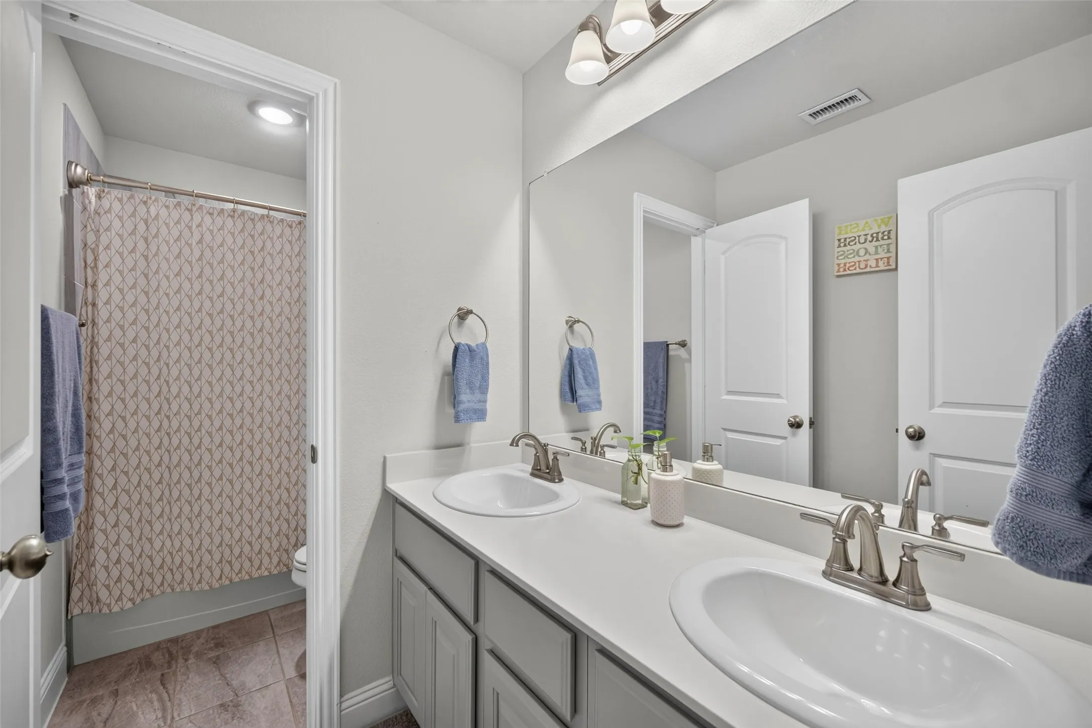 Double vanity with integrated sinks and brushed nickel fixtures
