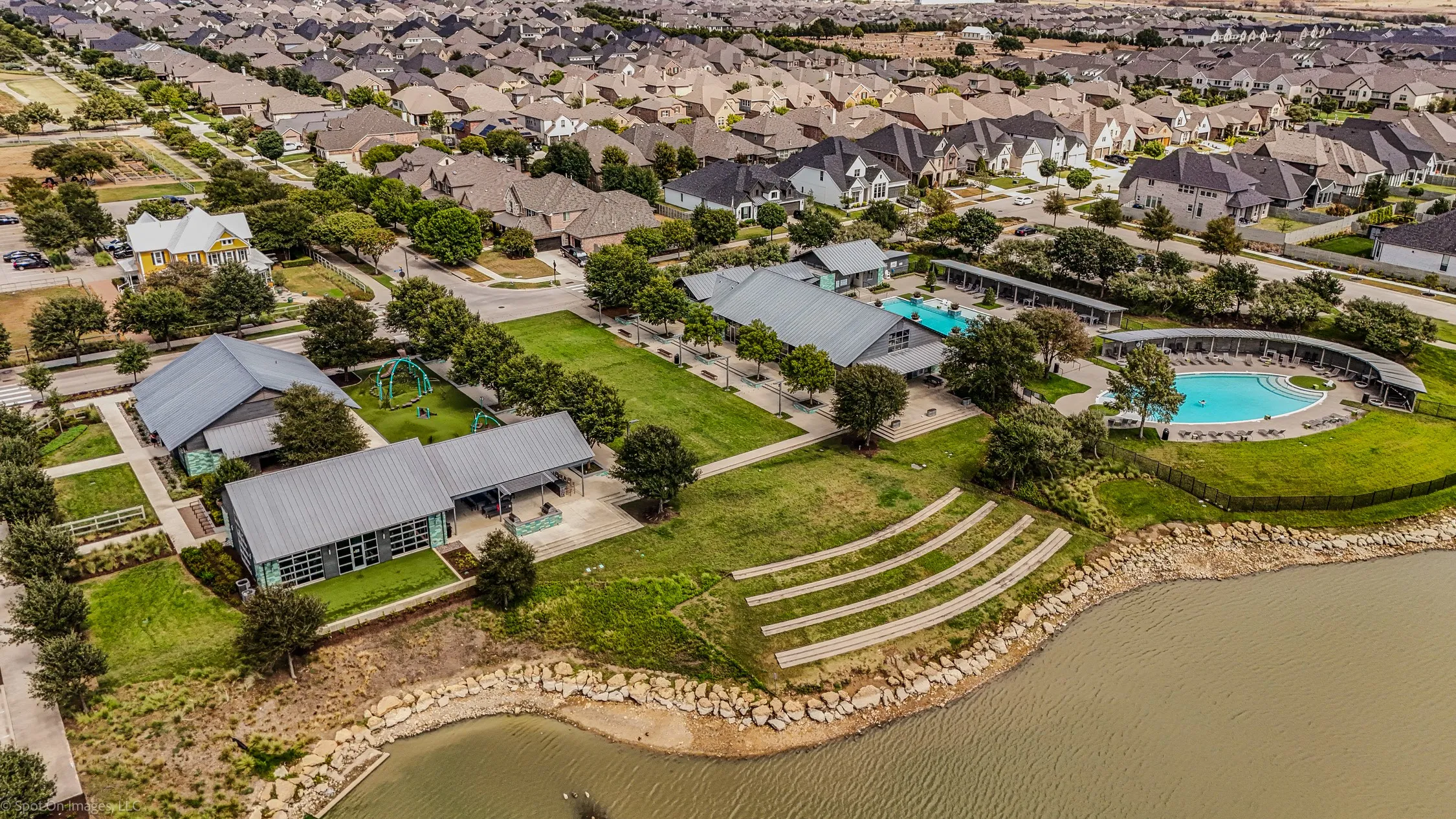 Outdoor amphitheaters and covered gathering spaces along with Two large pools with the large pond at the Amenity Center South located in Argyle, Texas in Harvest by Hillwood for 1302 20th St. in Denton County. Both of these amenity centers have state of the art workout centers.