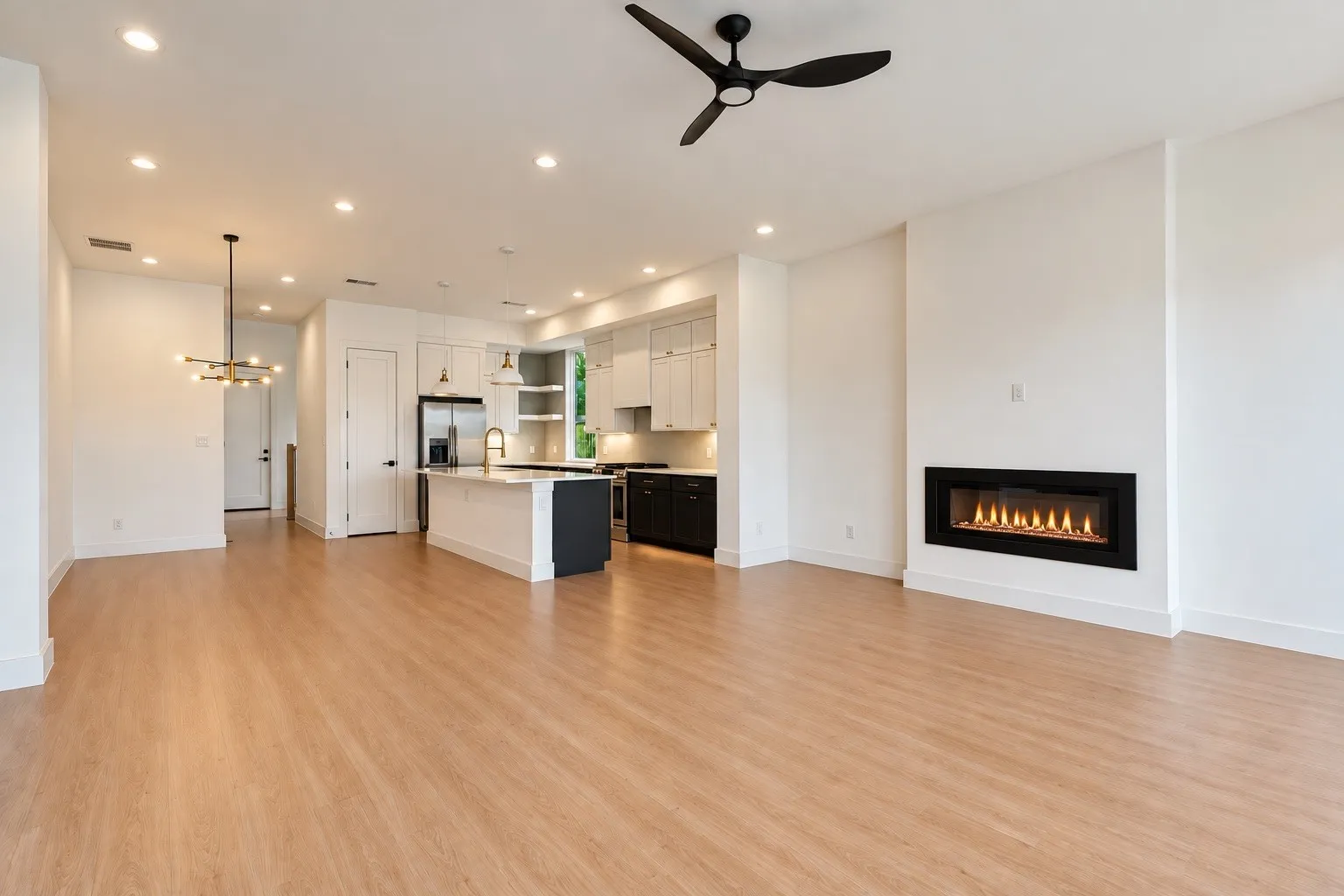 Open-concept living area featuring wood-finish flooring, a linear electric fireplace, and recessed lighting
