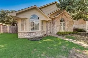 Brick and siding exterior with arched windows, prominent bay window, and gabled roofline