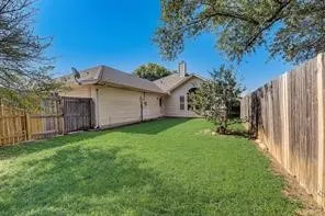 Expansive fenced yard with a manicured lawn and mature landscaping