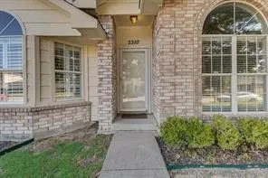 Brick facade with arched window, bay window, and concrete walkway