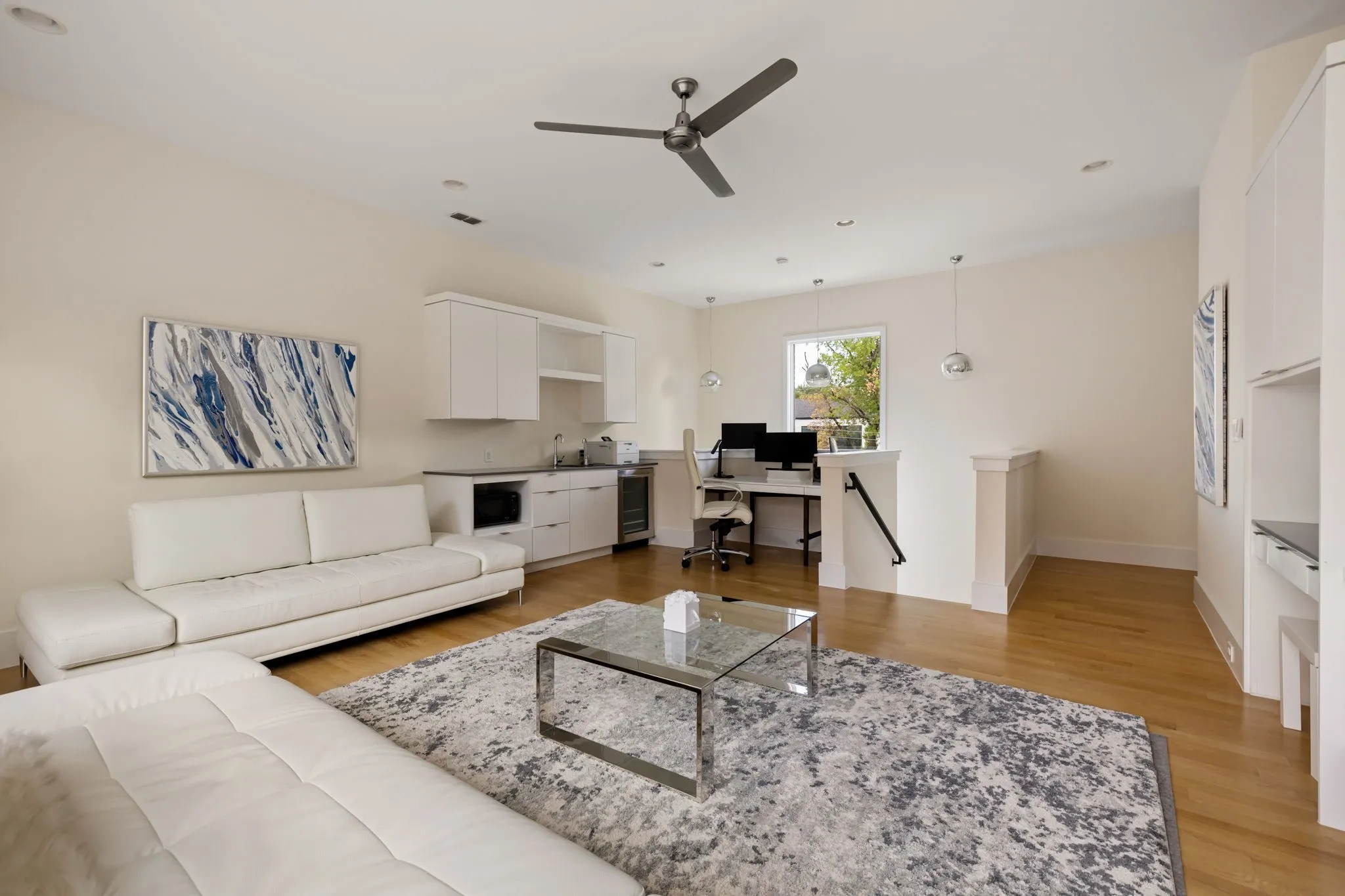 Hardwood flooring, recessed lighting, ceiling fan, built-in cabinetry with integrated sink, and a built-in desk area
