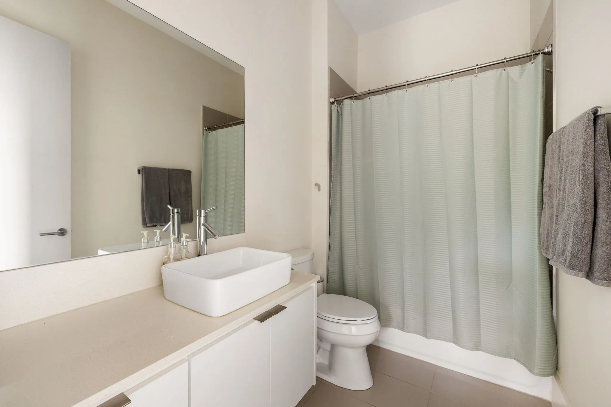 Vanity with a rectangular vessel sink, contemporary faucet, and white cabinetry