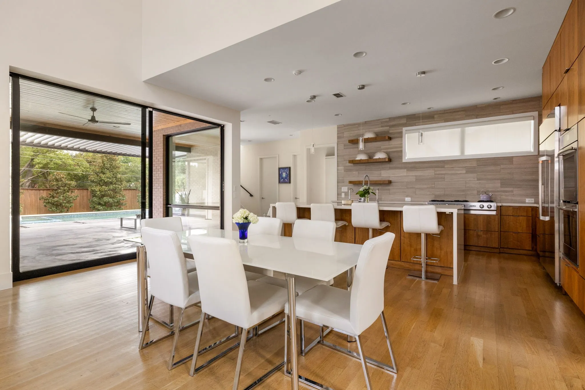 Two-story living area with high ceilings, wood-finish flooring, and a dining area