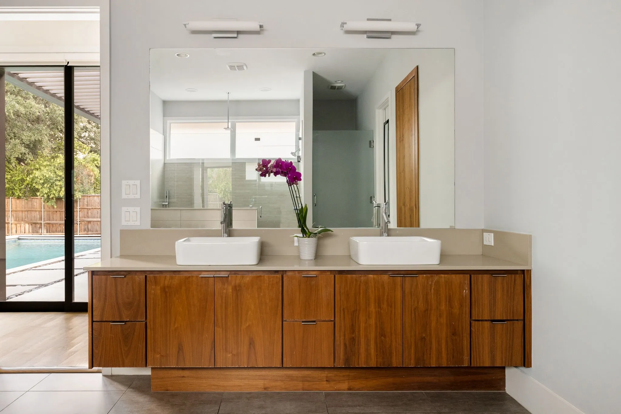Double vanity featuring wood-finish cabinetry and a light-toned countertop