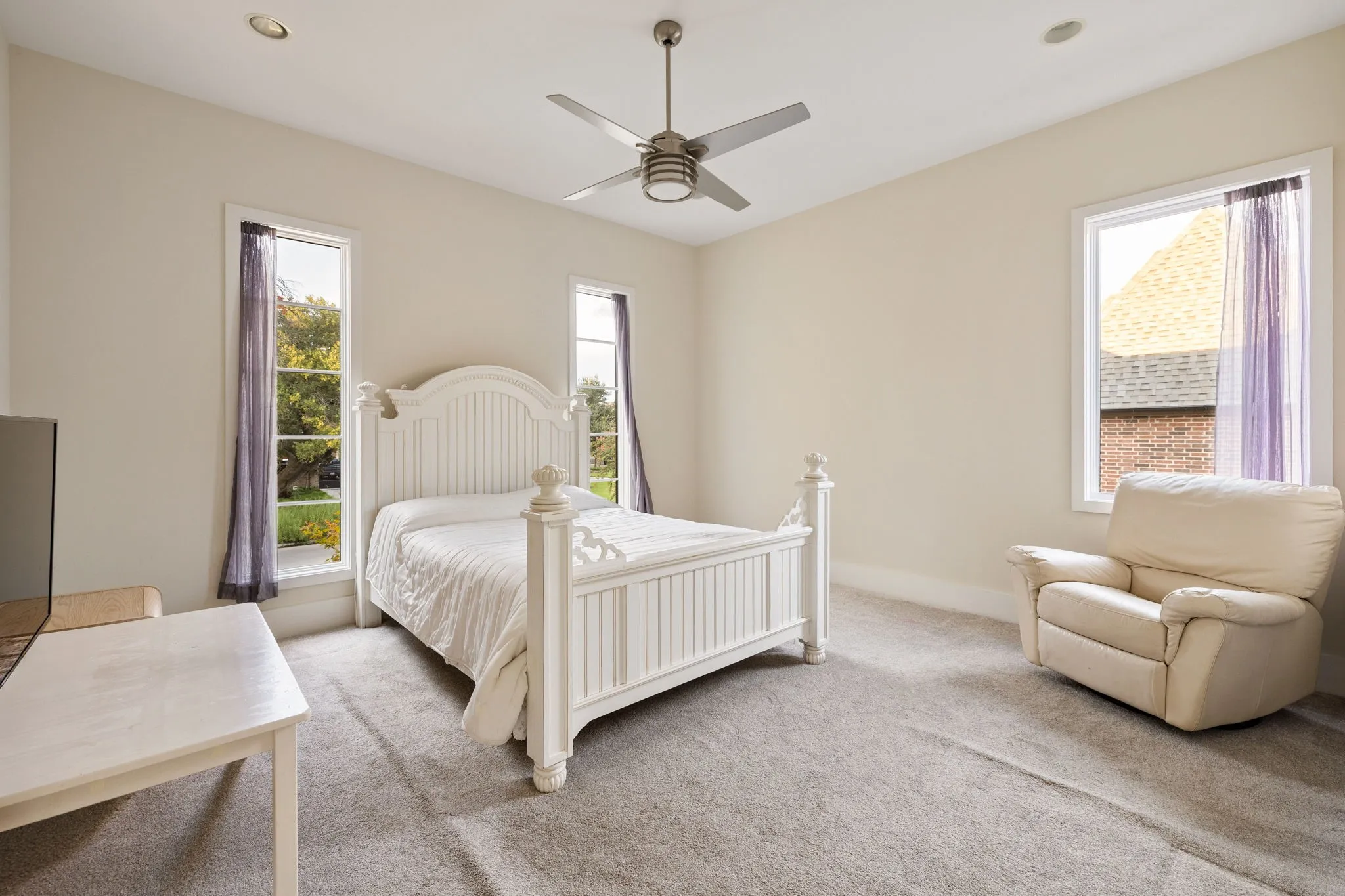 Bright room featuring recessed lighting, a ceiling fan, and multiple windows