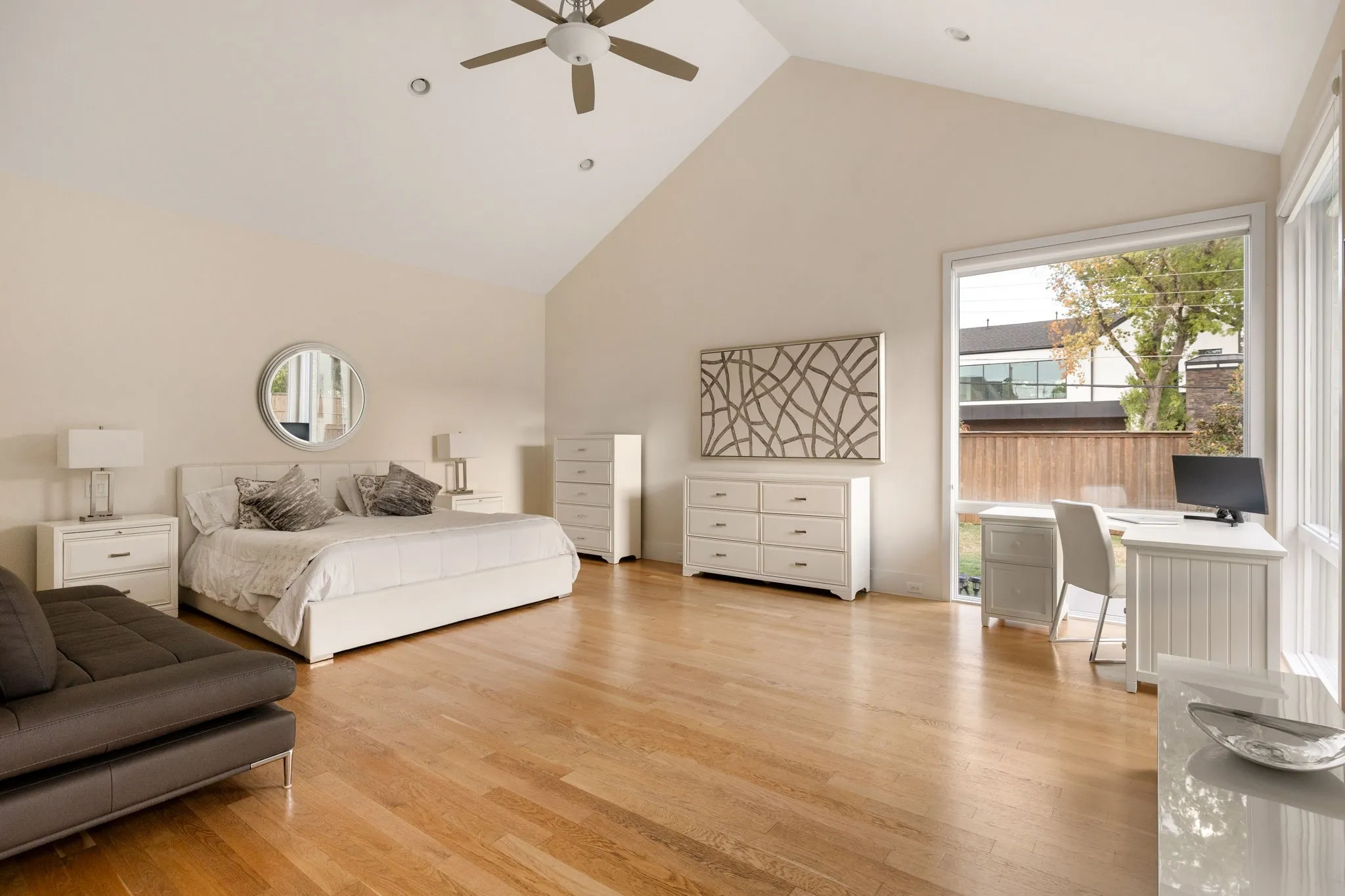 Vaulted ceilings featuring a ceiling fan, recessed lighting, wood-finish flooring, and large windows