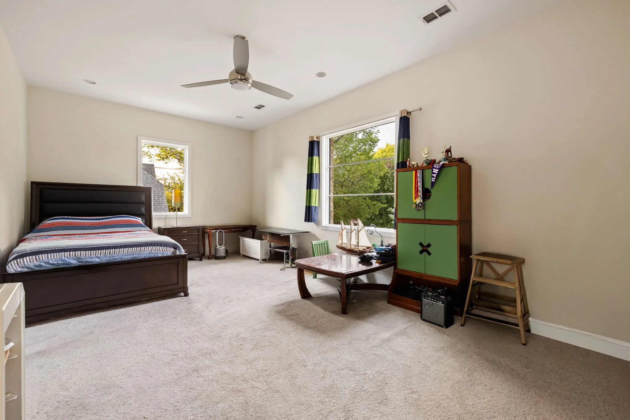 Expansive room featuring light-colored walls, recessed lighting, and a ceiling fan