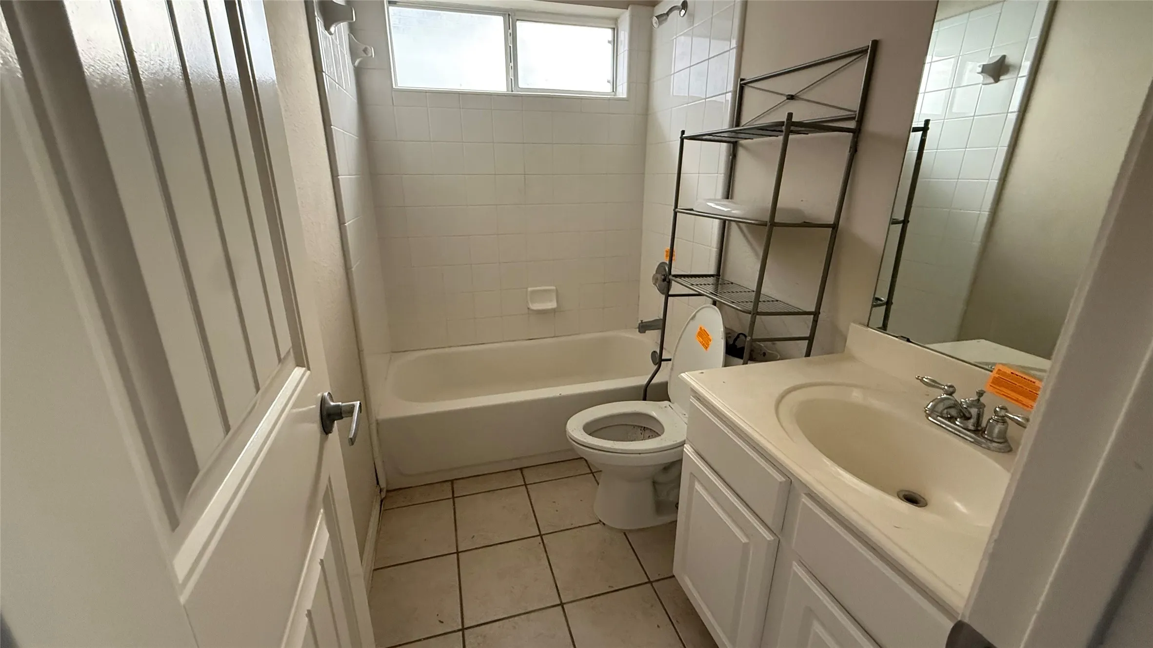 Bathroom with a white vanity, integrated sink, and chrome faucet