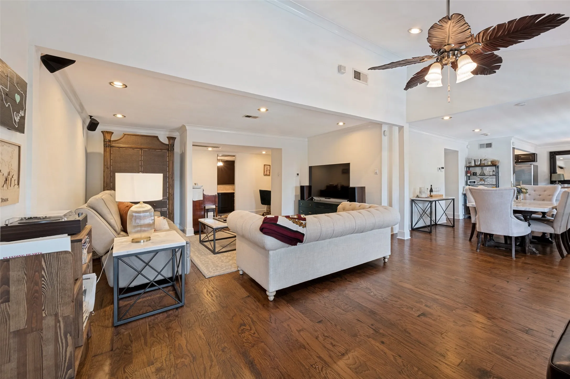 Rich wood-finish flooring throughout, recessed lighting, and a decorative ceiling fan