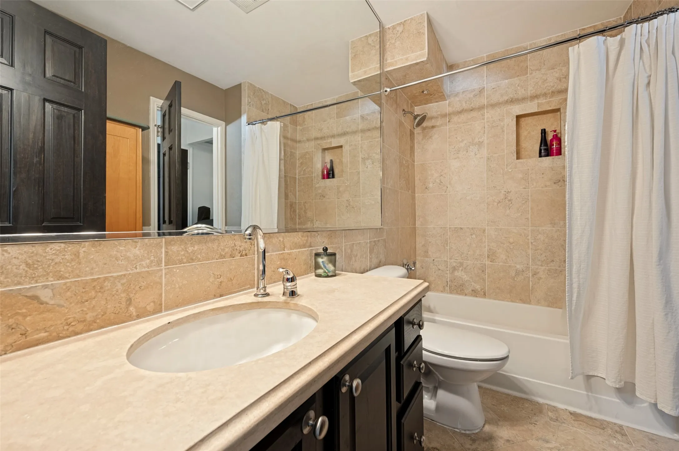 Vanity with an integrated oval sink, chrome-finish faucet, and a light-toned countertop