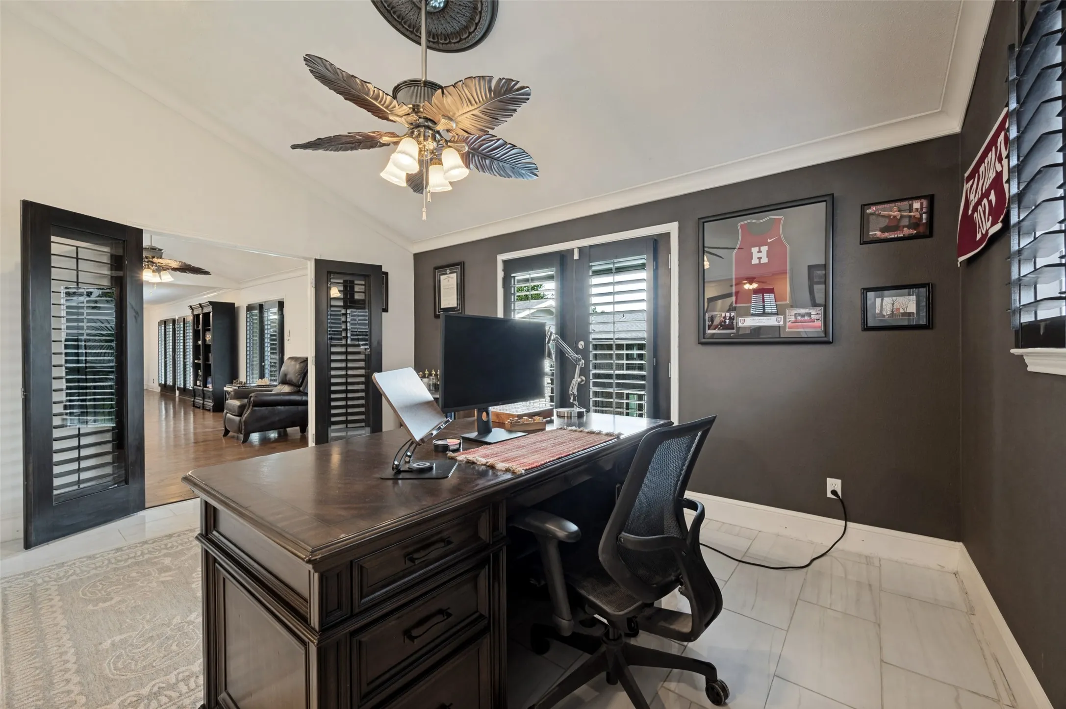 Vaulted ceiling with an ornate ceiling medallion, plantation shutters, and light-toned tile flooring