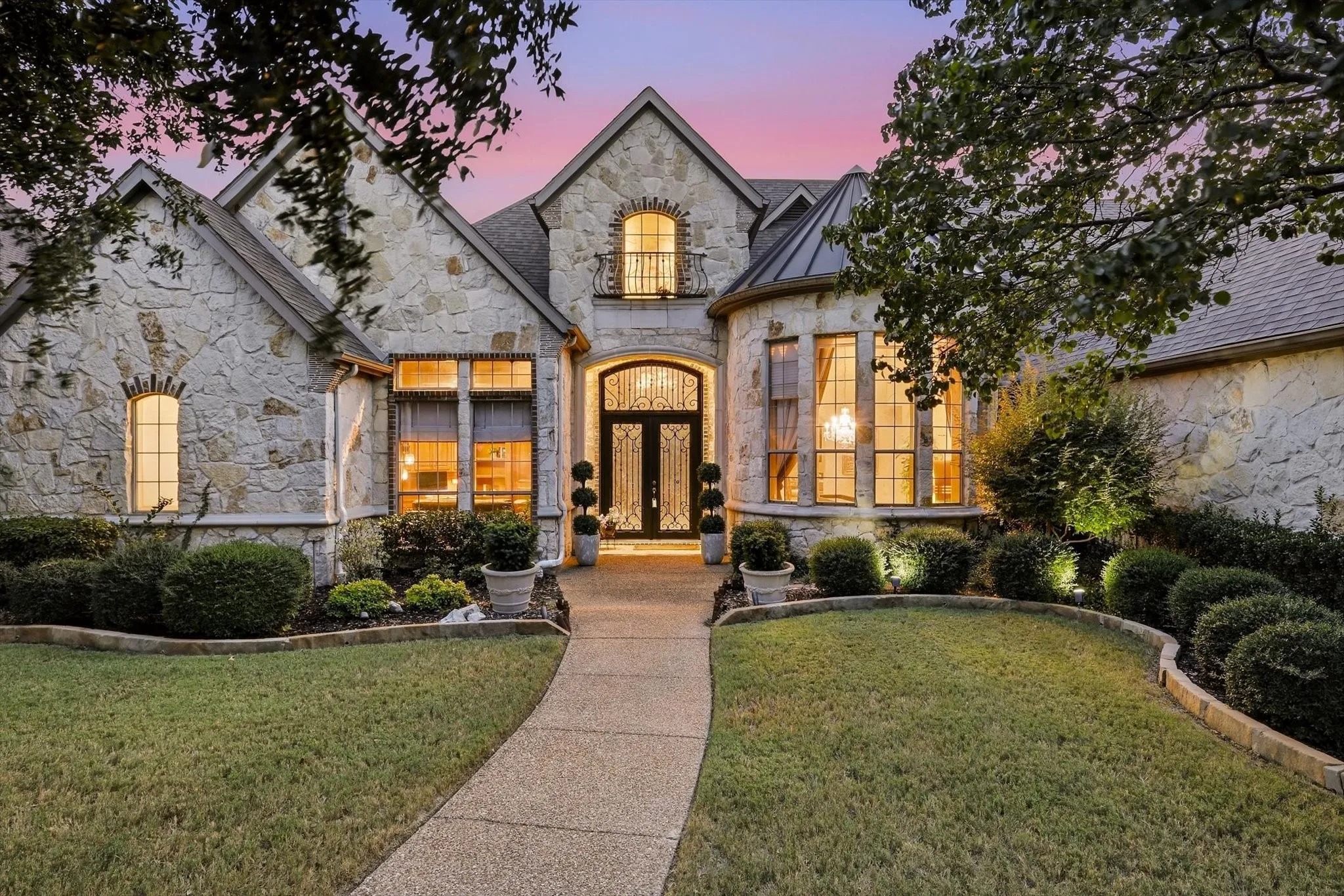 Mature landscaping, beautiful stonework and a distinctive wrought-iron front door create a welcoming entrance with exceptional curb appeal.